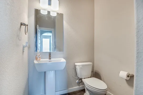 a bathroom with a toilet a sink and mirror