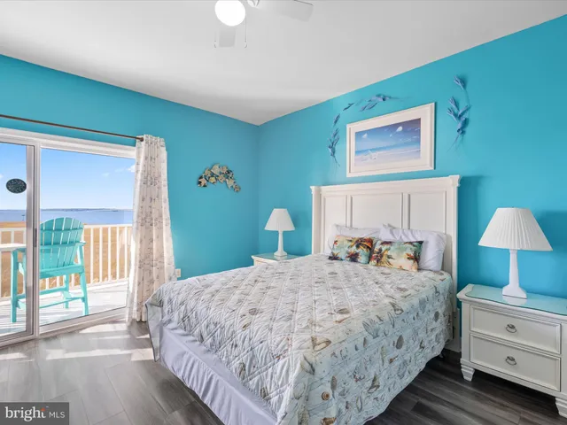 a bedroom with a bed and a lamp on dresser