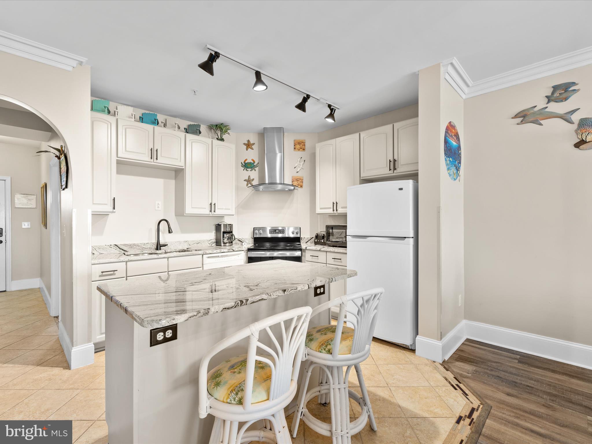 105 56th Street, Unit 205 P1 Ocean City, MD 21842 - Photo 5 of 40 a kitchen with stainless steel appliances granite countertop a refrigerator and a stove top oven
