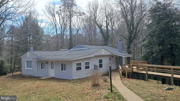 a front view of a house with a garden and trees