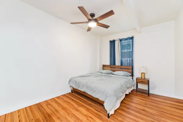 a bedroom with a bed and wooden floor