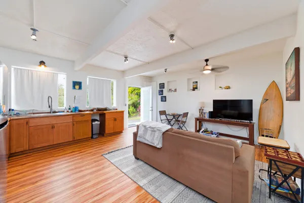 a large living room with stainless steel appliances kitchen island granite countertop a couch and a view of living room