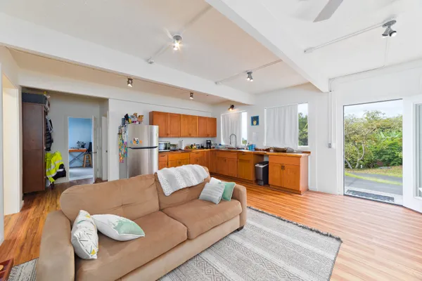 a living room with furniture kitchen view and a large window