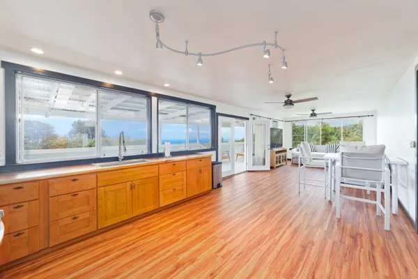 a large kitchen with sink and wooden floor