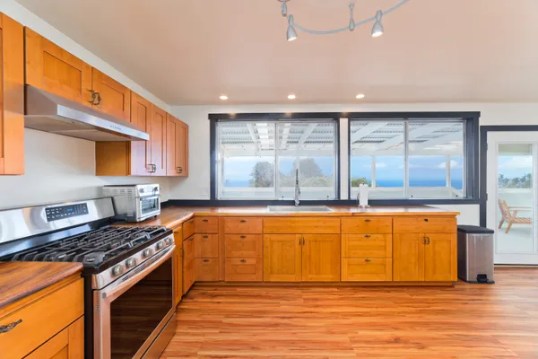 a large kitchen with stainless steel appliances granite countertop a stove and a sink