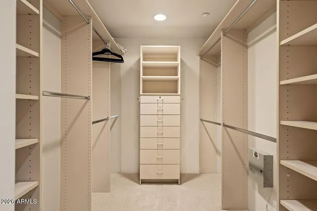 a view of walk in closet with empty racks