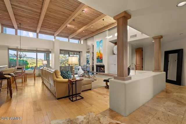 a living room with fireplace furniture and a large window