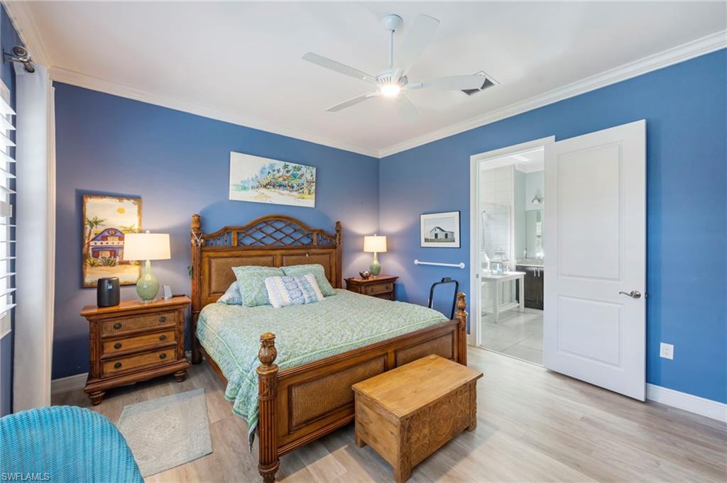 1287 Manado Drive Naples, FL 34113 - Photo 14 of 32 a bedroom with a bed and wooden floor