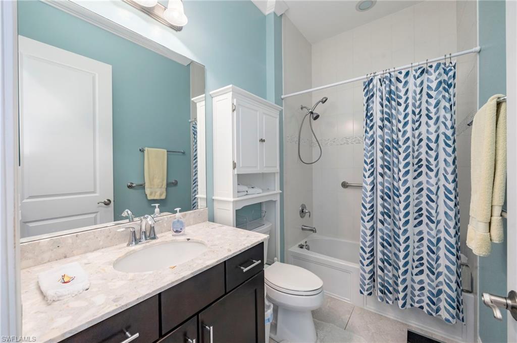 1287 Manado Drive Naples, FL 34113 - Photo 17 of 32 a bathroom with a sink toilet a mirror and shower