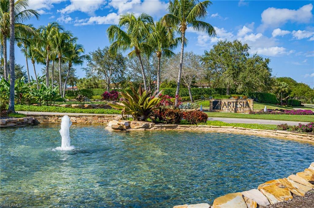 1287 Manado Drive Naples, FL 34113 - Photo 25 of 32 a view of a swimming pool with a lawn chairs and palm trees