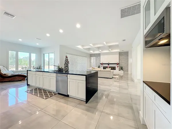 a kitchen with stainless steel appliances a sink a stove a refrigerator cabinets and dining table