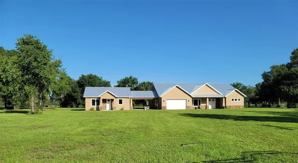 a view of house with garden and trees