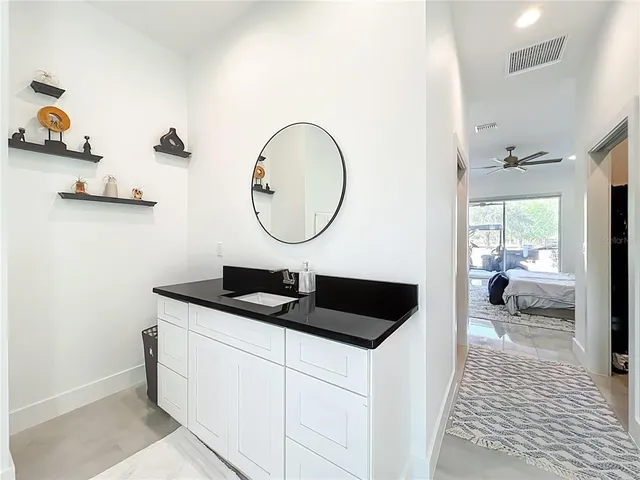 a bathroom with a granite countertop sink and a mirror