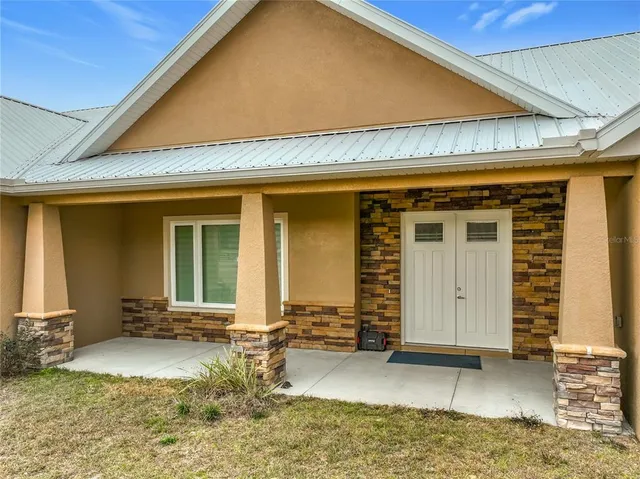 a view of a house with a yard and sitting area