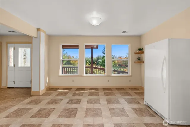 a view of a bedroom with a window and a refrigerator