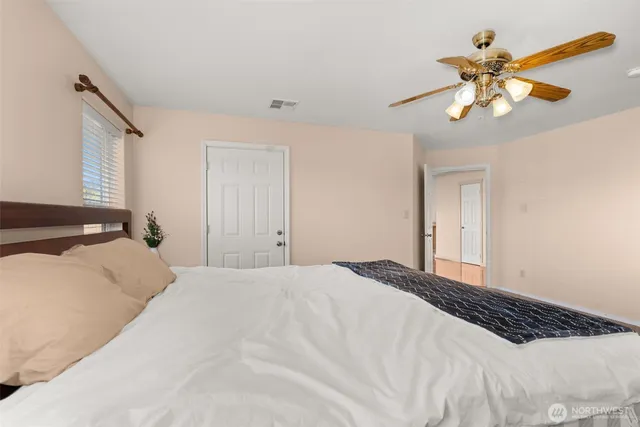 a bedroom with a large bed and a chandelier
