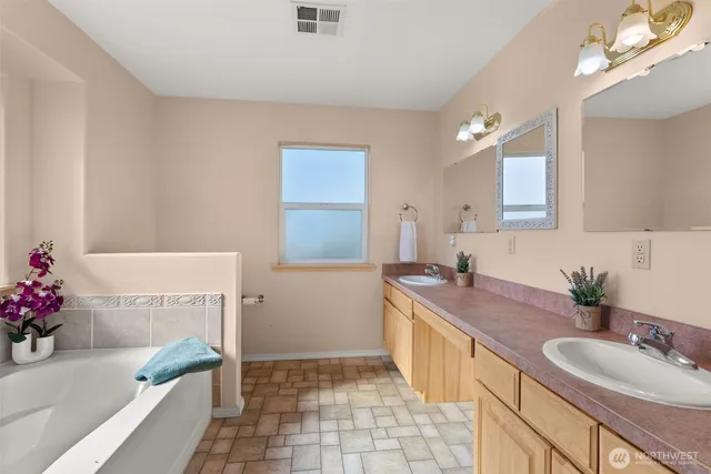 a spacious bathroom with a granite countertop tub sink and mirror