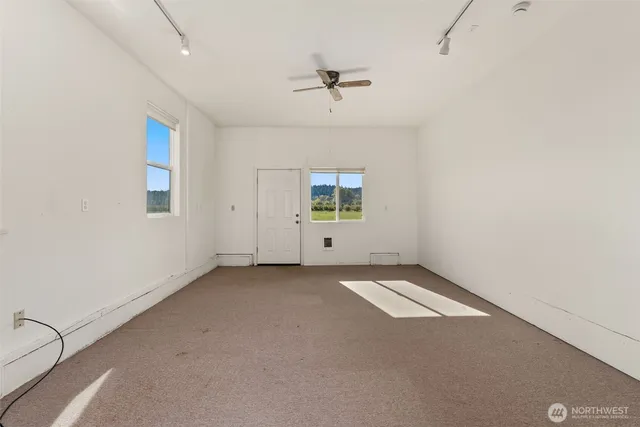 an empty room with a ceiling fan and a window
