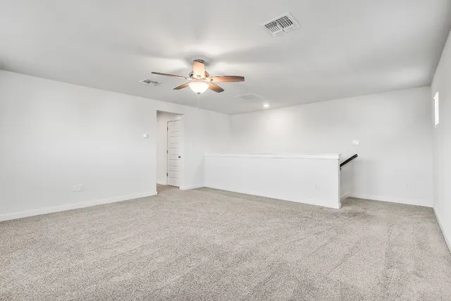 an empty room with a window and a ceiling fan