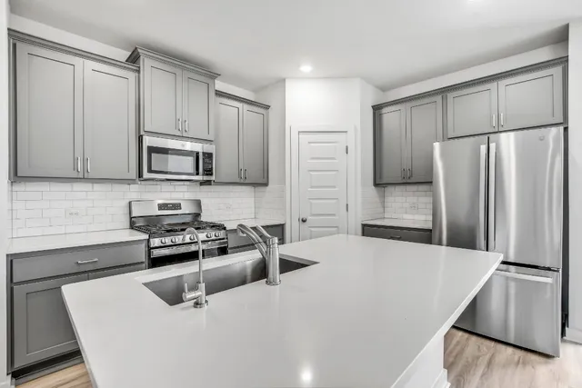 a kitchen with stainless steel appliances granite countertop a refrigerator sink and stove