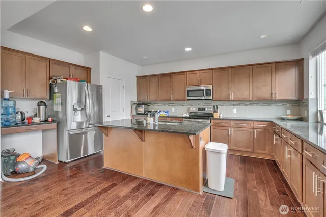 a kitchen with stainless steel appliances a refrigerator stove microwave and cabinets