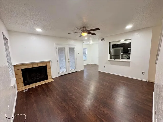 an empty room with wooden floor fireplace and a window