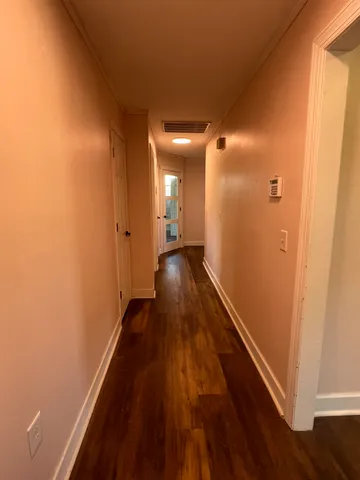 a view of a hallway with wooden floor