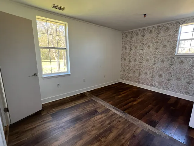 a view of a room with wooden floor and window