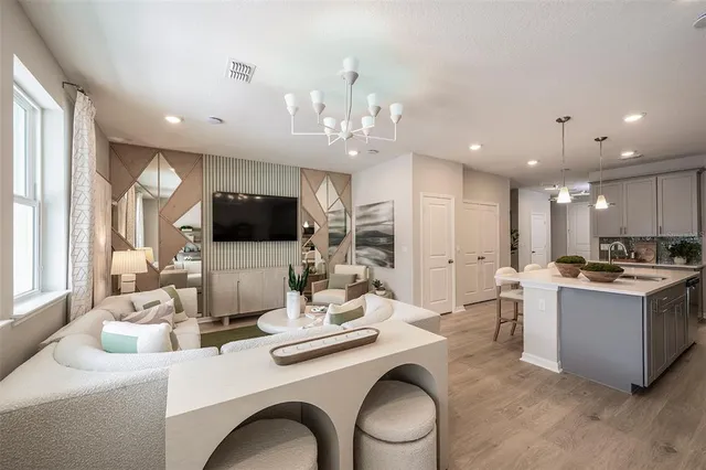 a living room with kitchen island furniture and a flat screen tv