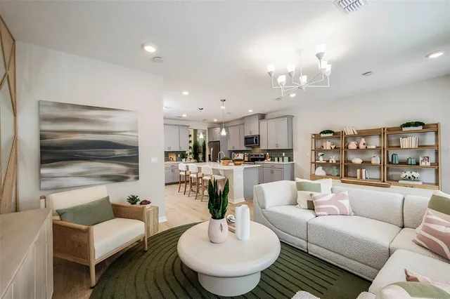 a living room with furniture kitchen and a table