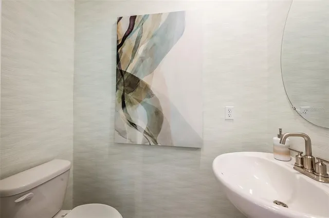 a bathroom with a sink mirror and toilet