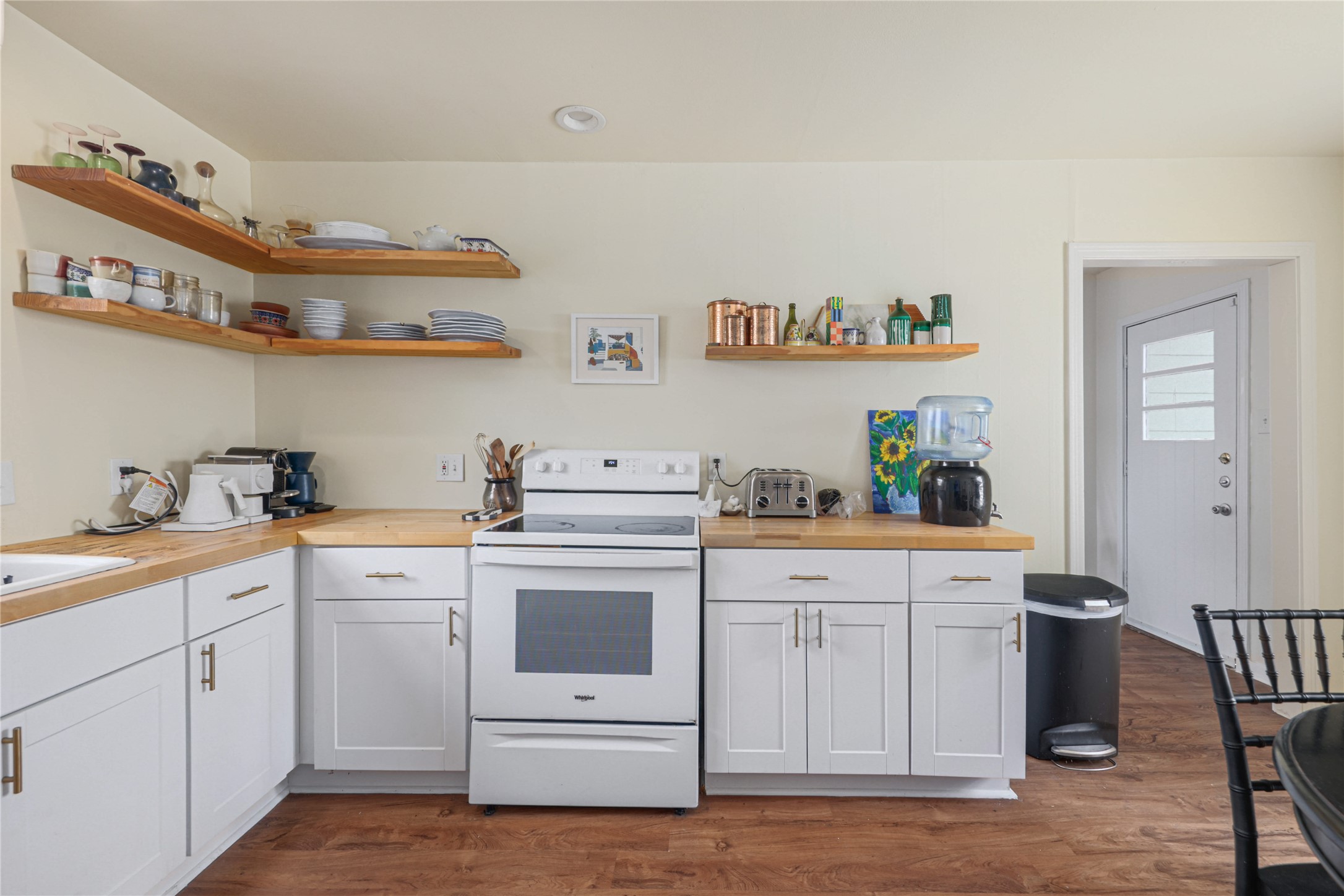 4607 Evans Avenue, Unit B Austin, TX 78751 - Photo 19 of 34 Kitchen featuring wood-finish flooring, white cabinetry with contemporary hardware, light wood-finish countertops, and open shelving
