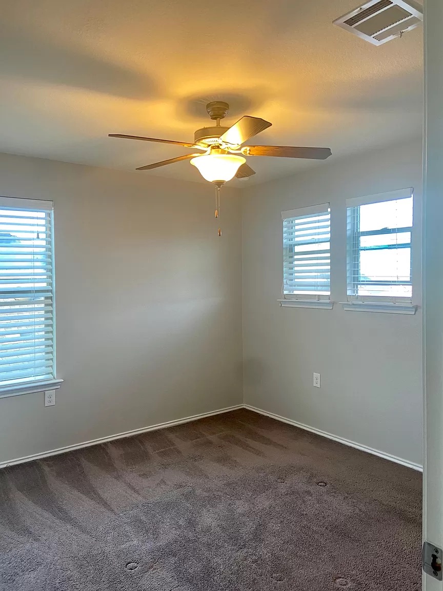9016 Ridgewell Road Austin, TX 78747 - Photo 24 of 30 A comfortable bedroom features carpeted floors and a ceiling fan with integrated lighting.