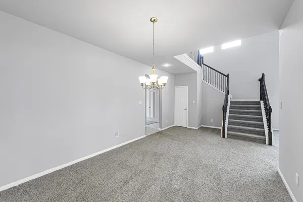 a view of a room with stairs and a chandelier fan