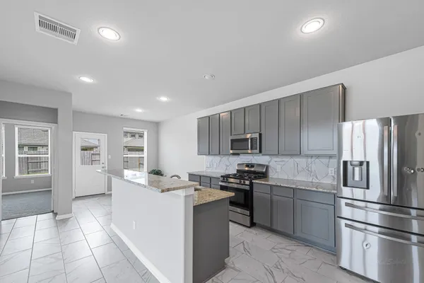 a kitchen with kitchen island a sink stainless steel appliances and cabinets