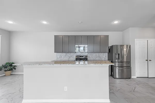 a kitchen with stainless steel appliances granite countertop a refrigerator sink and stove