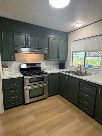 a kitchen with a sink stove and cabinets