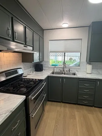 a kitchen with granite countertop a stove and a sink
