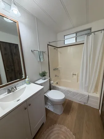 a bathroom with a double vanity sink toilet mirror and shower