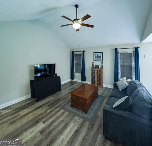 a living room with furniture and a ceiling fan