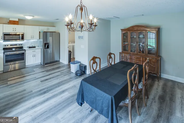 a view of a large pool with a lawn chairs under an umbrella