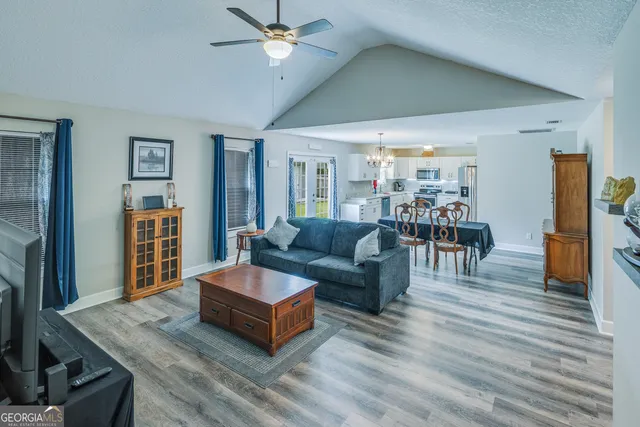 a view of a kitchen with wooden floor refrigerator and window