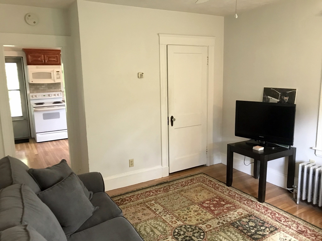 393 West Street, Unit 2 Walpole, MA 02081 - Photo 13 of 21 a living room with furniture and a flat screen tv