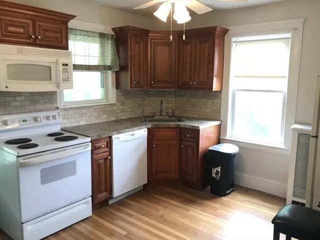 a kitchen with granite countertop a sink a stove and cabinets