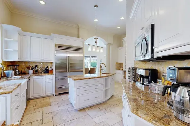 a kitchen with stainless steel appliances granite countertop a sink counter space cabinets and a stove