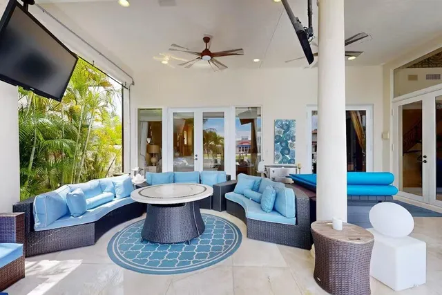 a living room with patio furniture and a potted plant