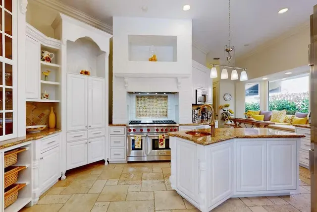 a kitchen with stainless steel appliances granite countertop a stove and more cabinets