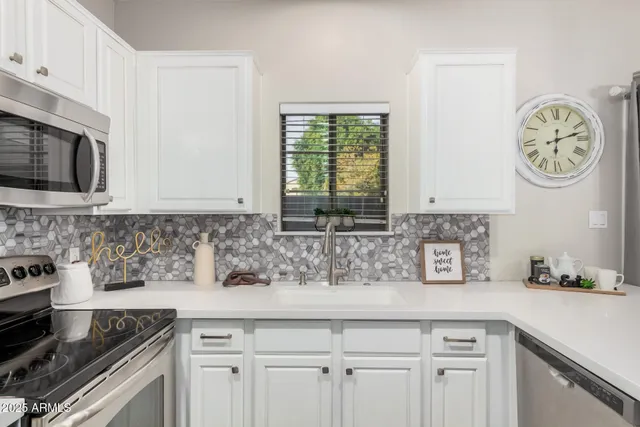 a kitchen with stainless steel appliances granite countertop a sink a stove and cabinets