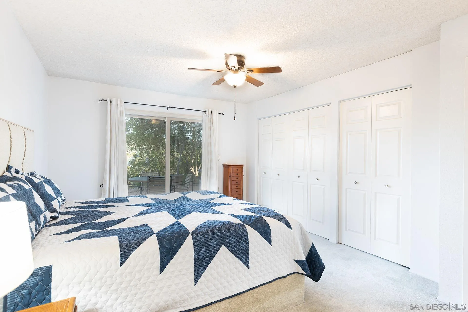 12455 Ridgeton Drive Lakeside, CA 92040 - Photo 13 of 31 a spacious bedroom with a bed and a chandelier