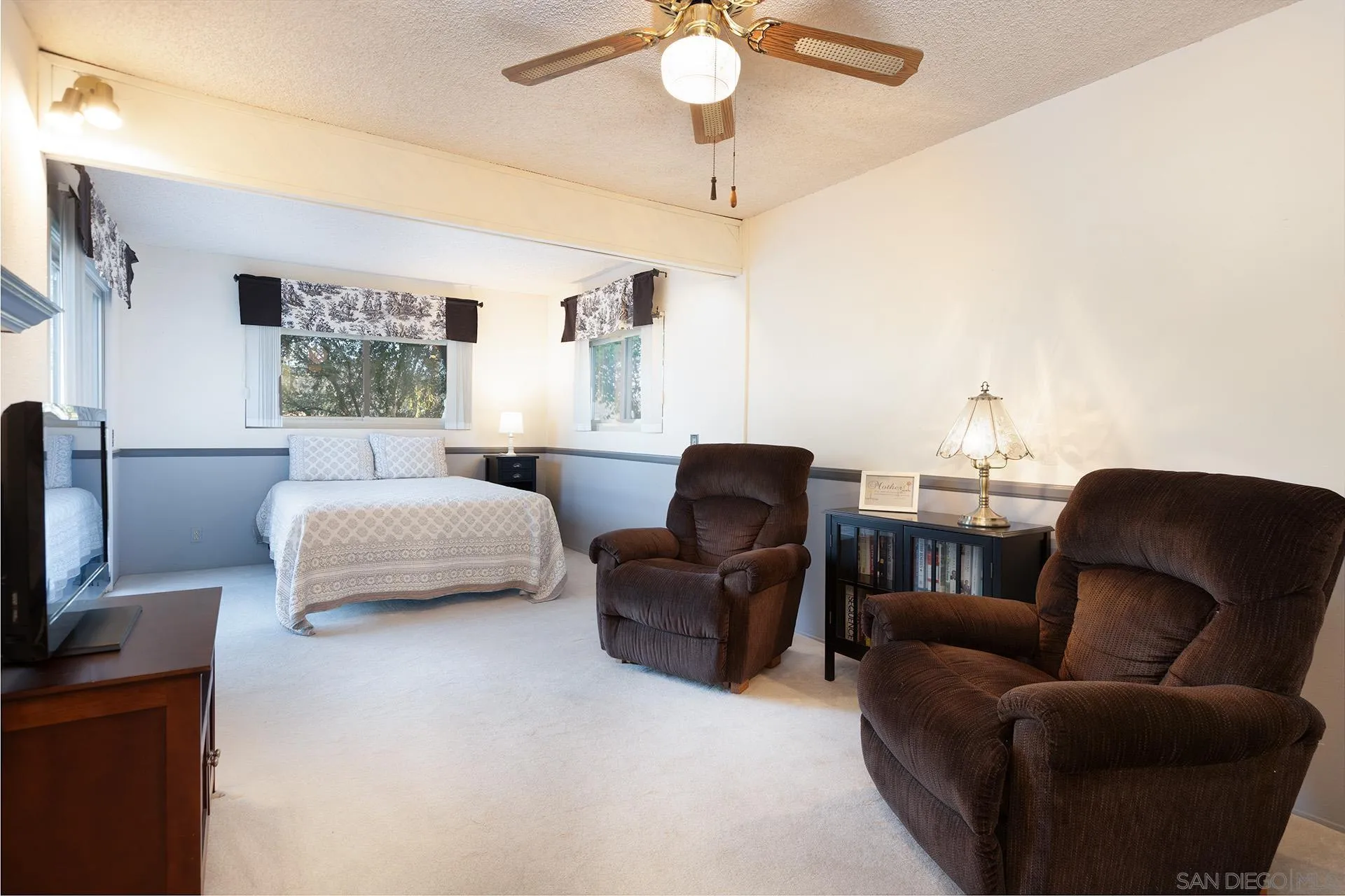 12455 Ridgeton Drive Lakeside, CA 92040 - Photo 16 of 31 a bedroom with a bed a couch and a chandelier